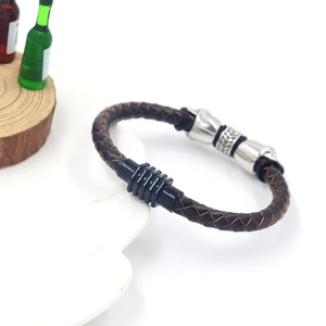 Detail of dark brown braided leather bracelet with skull beads and black magnetic clasp