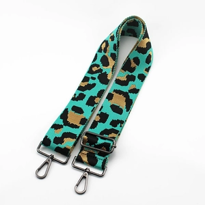 Detail of adjustable green leopard print bag strap with durable grey lobster clasps