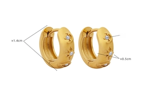 Vue détaillée des boucles d'oreilles dorées avec gravures soleil lune et zircons