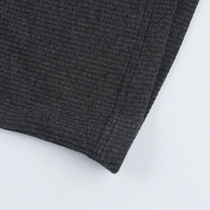 Gros plan détaillé du tricot côtelé gris foncé montrant les coutures et la finition soignée