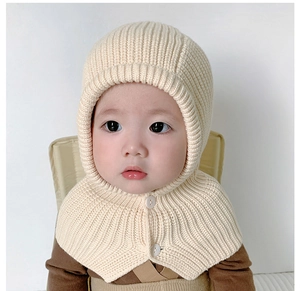 Close-up of beige knit baby hooded scarf hat with two white buttons for secure fit