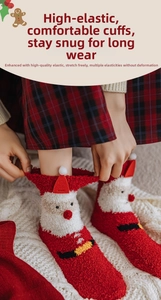 Detail of red coral fleece Christmas socks featuring Santa Claus patterns and pom-poms
