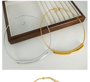 Detailed macro view of gold and silver minimalist curved tube snake chain necklaces