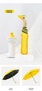 Detail of creative duck head wooden handle on a yellow umbrella with black glue coating