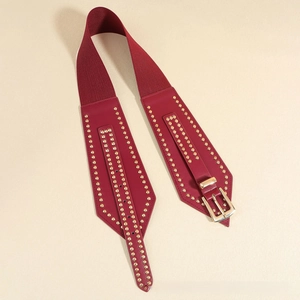 Close-up of burgundy elastic waist belt with gold rivet studs and metal buckle detail