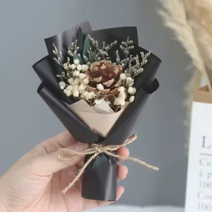 Detailed shot of a mini bouquet featuring a pine cone, baby's breath, and eucalyptus leaf