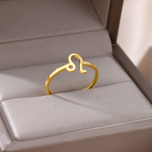 Macro shot of minimalist gold Leo zodiac ring on a velvet jewelry display tray