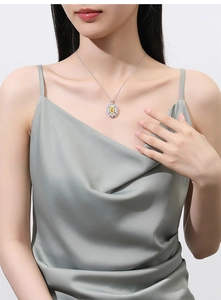 Detail of flower shaped pendant necklace with a square yellow stone and white diamonds