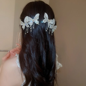 Detail of elegant butterfly hair clips with shimmering tassels on dark wavy hair