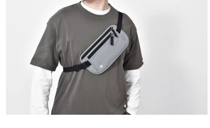 Detail of light grey waterproof RFID waist bag with multiple zip compartments and headphone port