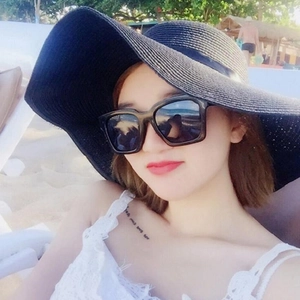 Women's black wide-brim woven straw hat with ribbon and sunglasses for beach vacation