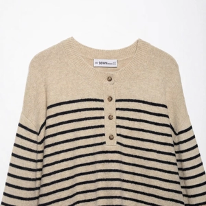 Pull en maille rayé beige classique avec rayures noires et col henley à boutons