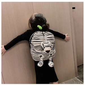Close-up of zebra pattern kids backpack with a cute matching plush tiger toy detail