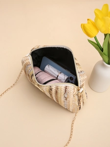 Detail view of the colorful straw bag interior showing a phone, lipstick and mini umbrella