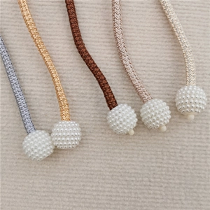 Detail of woven curtain tiebacks featuring lustrous pearl ball beads in various colors