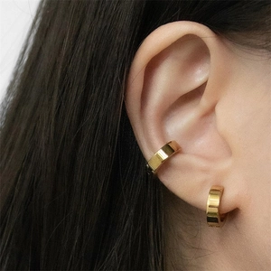 Detail of minimalist gold-plated stainless steel ear cuffs worn on the earlobe