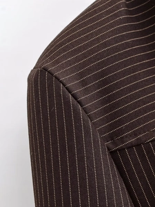 Detailaufnahme der Schulternähte und Nadelstreifen-Textur des dunkelbraunen Blazers