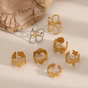 Gold hollow flower and starfish titanium steel rings on stone background for women