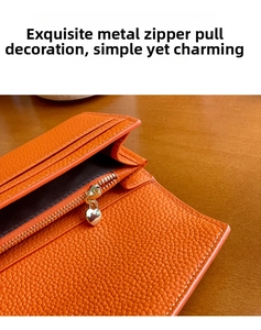 Makro-Detail einer orangefarbenen Lederbrieftasche mit herzförmigem Metall-Reißverschluss