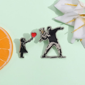 Artistic Banksy style enamel pins featuring Girl with Balloon and Flower Thrower designs