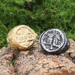Detailed view of vintage Egyptian portrait and skull rings on natural mossy wood