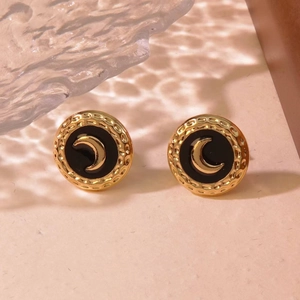 Macro detail of vintage gold round earring with black enamel and crescent moon design
