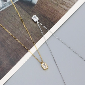 Detailed view of rectangular zircon pendants in gold and silver finish on S925 silver chains