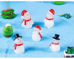 Miniature resin snowmen and Christmas trees on blue sand for DIY landscape decor