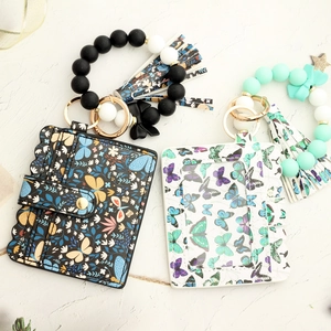 Detail view of butterfly print PU leather card holder and silicone bead keychain sets