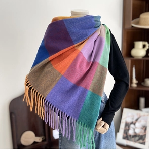 Detailed view of colorful large plaid scarf with fringe in soft cashmere-like texture