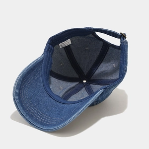 Detail view of denim baseball cap interior showing 100% cotton fabric and stitching