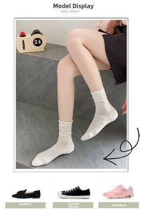 Detail of white mesh lace crew socks with ruffled cuffs and hollow knit texture