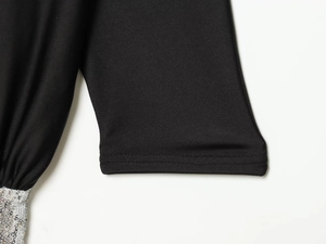 Detailed view of silver sequins and double-stitch hem on a black long sleeve mini dress