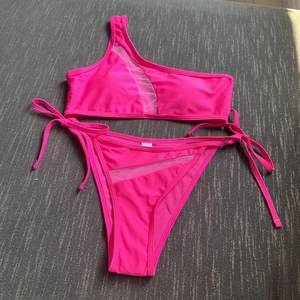 Hot pink one-shoulder cutout bikini set with mesh panels and side-tie bottom details