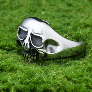Gothic skull open cuff bracelet in polished stainless steel on a natural green moss background