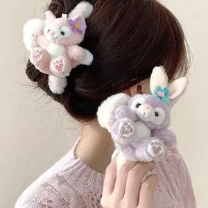 Detail of plush cartoon hair ties featuring pink fox and purple rabbit with floral accents