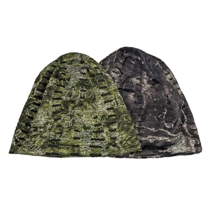 Detail of ripped camo and marble grey knit beanies with distressed holes in flat lay