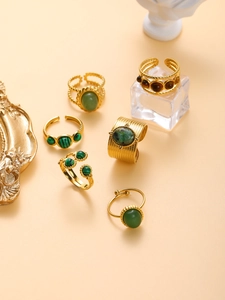 Artistic layout of gold vintage chunky rings with green and brown stone inlays