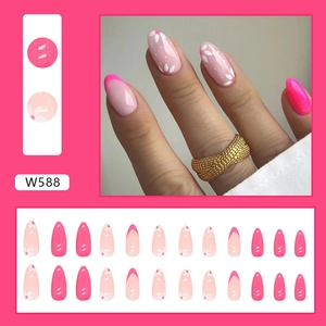 Detail of pink press-on nails featuring white daisy patterns and French tips in W588 style