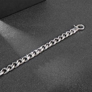 Detail eines silbernen Panzerarmbands aus Titanstahl mit graviertem Karabinerverschluss