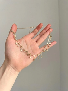 Detail of gold star pendant necklace with delicate chain and lobster clasp closure
