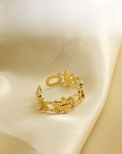 Detailed close-up of 18K gold-plated adjustable hollow ring on soft yellow silk fabric