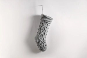 Detail of grey cable knit Christmas stocking with thick yarn texture for holiday decor