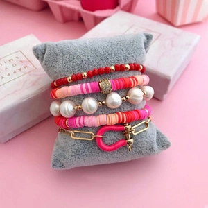 Macro shot of 5-piece pink boho bracelet set with freshwater pearls and clay beads