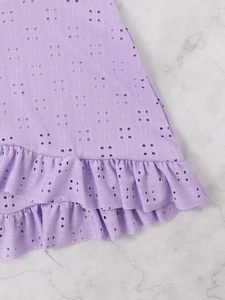 Detail of lavender eyelet lace fabric with double-layered ruffles on marble backdrop