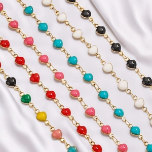 Macro view of colorful enamel heart pendants on gold stainless steel jewelry chain