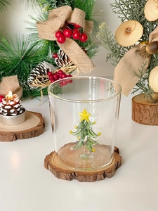 Detail of clear glass cup with a 3D green Christmas tree inside for holiday drinks