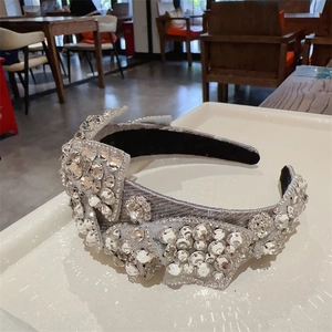 Detailaufnahme eines glitzernden silbernen Haarreifens mit Strass und Schleife