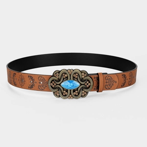 Detail of vintage brown leather belt with engraved bronze buckle and blue gemstone