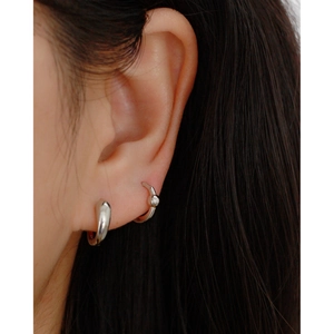 Detailed close-up of s925 silver minimalist hoop earrings with beads on a female ear